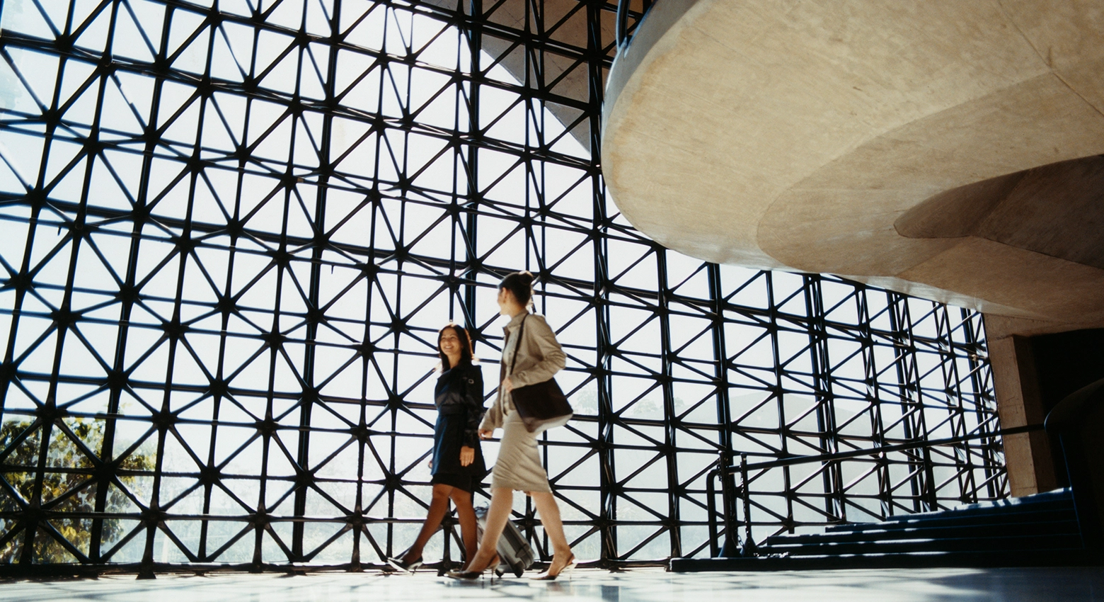 Dwie kobiety przechadzające się po firmowym biurze 