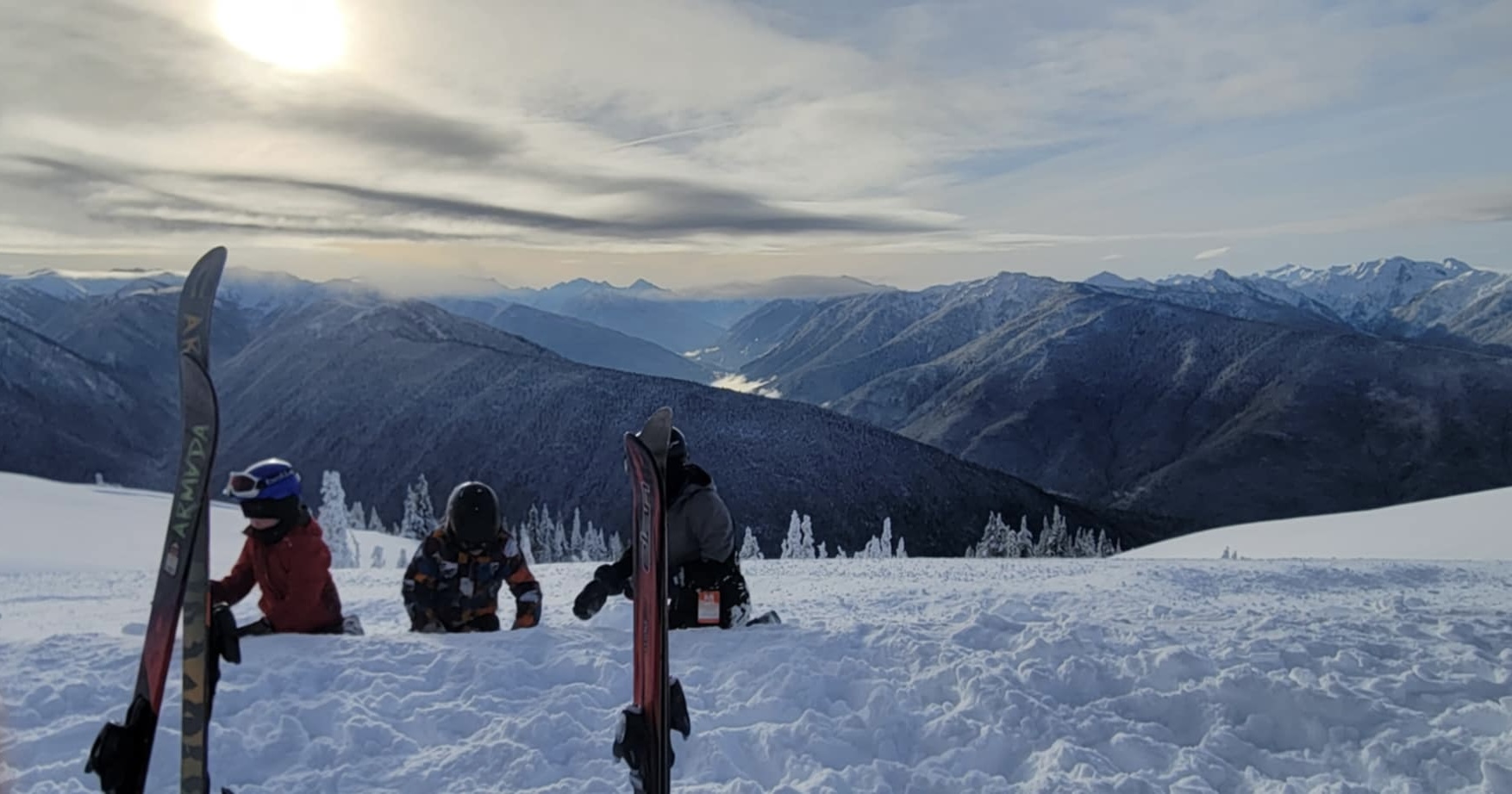 osoby jeżdżące na nartach o zachodzie słońca
